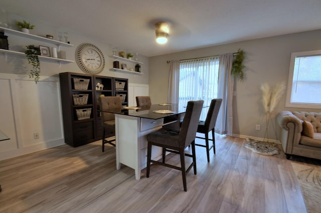 dining space with light wood-style flooring and baseboards