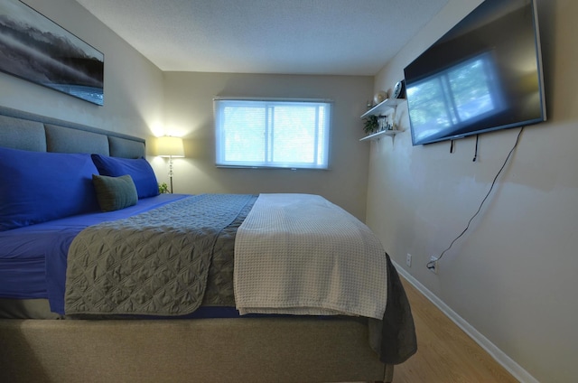 bedroom featuring wood finished floors and baseboards