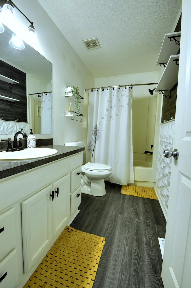 bathroom featuring wood finished floors, visible vents, shower / bath combo, a textured ceiling, and toilet