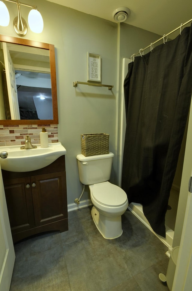 bathroom featuring toilet, curtained shower, tasteful backsplash, baseboards, and vanity