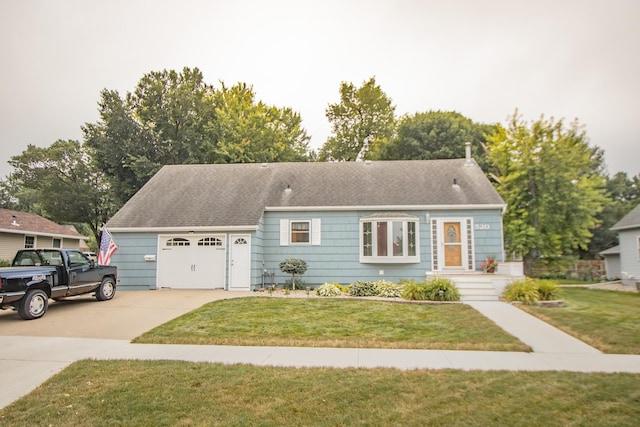 view of front facade featuring driveway, an attached garage, a front yard, and a shingled roof