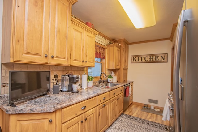 kitchen featuring visible vents, crown molding, dishwasher, light wood-style floors, and a sink