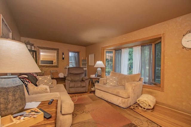 living area with wood finished floors and a textured wall