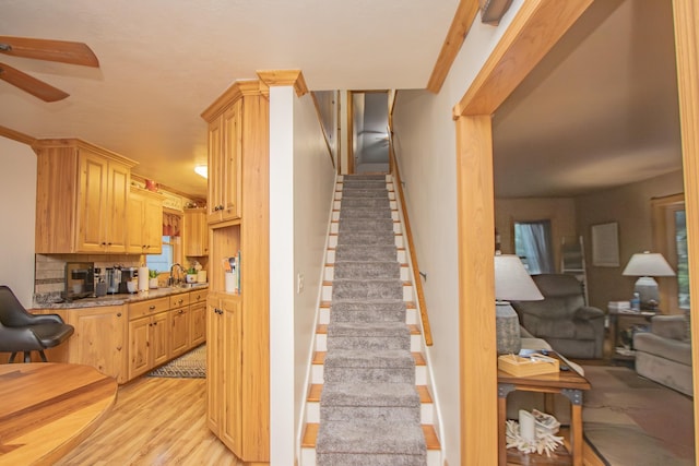 stairs featuring ceiling fan and wood finished floors