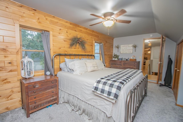 bedroom with wooden walls, ceiling fan, and carpet