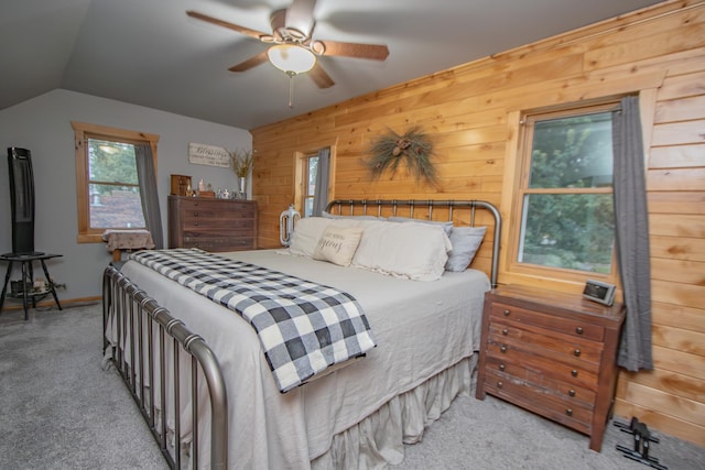 carpeted bedroom featuring wood walls, baseboards, lofted ceiling, and ceiling fan