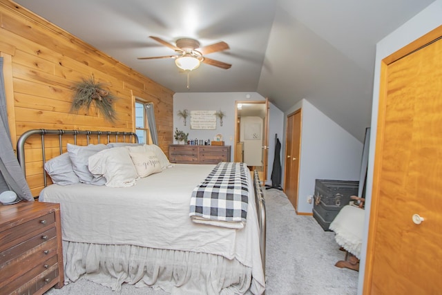 carpeted bedroom with lofted ceiling, wooden walls, and a ceiling fan