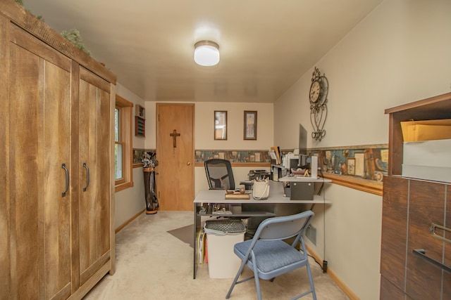 office area featuring light carpet and baseboards