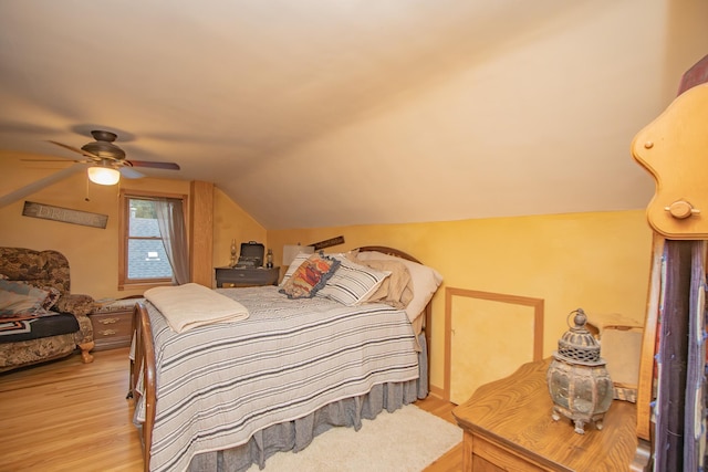 bedroom featuring lofted ceiling, a ceiling fan, and light wood-type flooring