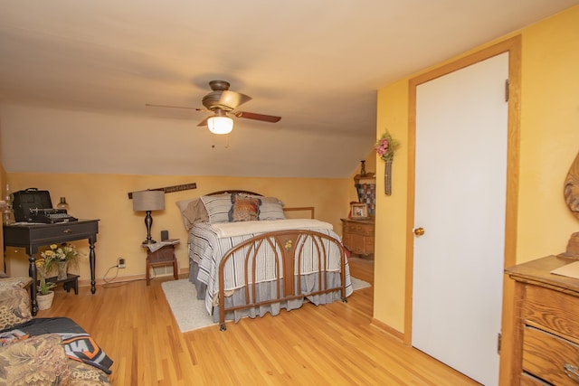 bedroom with baseboards, lofted ceiling, and light wood finished floors