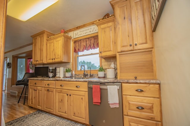 kitchen featuring tasteful backsplash, light wood-type flooring, ornamental molding, stainless steel dishwasher, and a sink