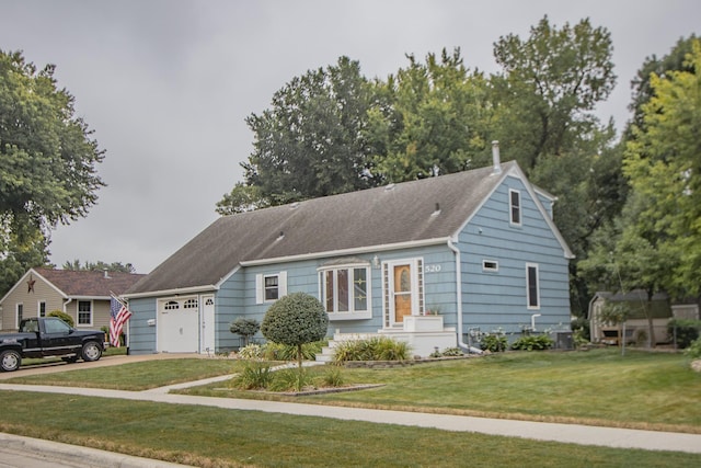 view of front of house featuring a front yard, an attached garage, cooling unit, and driveway