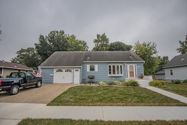 ranch-style house with a garage, concrete driveway, and a front yard