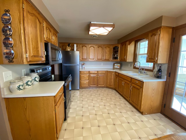 kitchen featuring a sink, light floors, brown cabinets, and stainless steel appliances