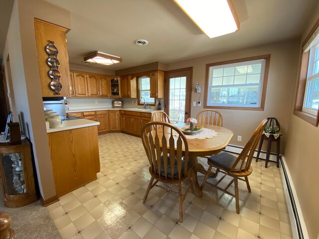 dining area featuring light floors, visible vents, baseboard heating, and baseboards