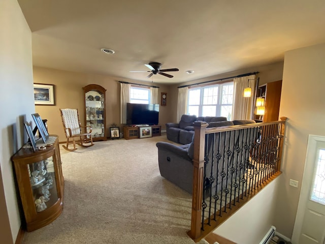 carpeted living area with visible vents, ceiling fan, and baseboards