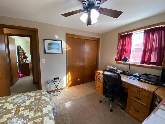 bedroom featuring a closet, light colored carpet, and a ceiling fan