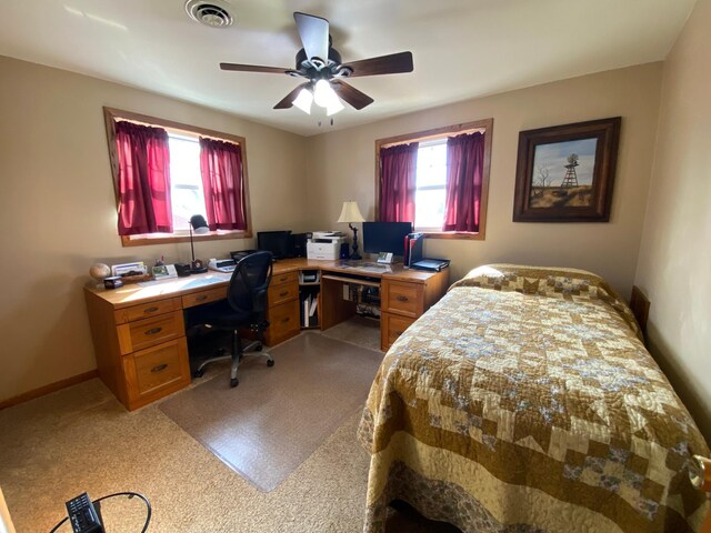 bedroom featuring a ceiling fan, multiple windows, baseboards, and visible vents