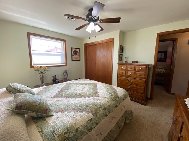 bedroom featuring a closet, light carpet, and ceiling fan