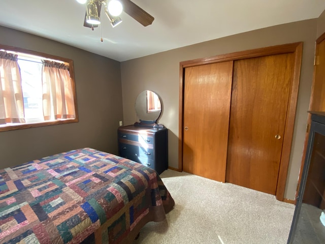 bedroom with a closet, a ceiling fan, and carpet floors