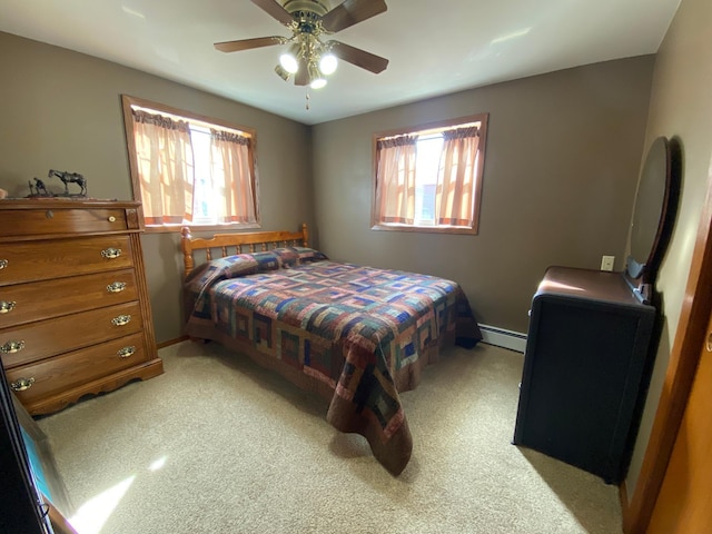 bedroom with ceiling fan, multiple windows, baseboards, and a baseboard radiator