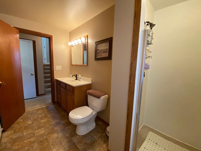 bathroom featuring toilet, vanity, and baseboards