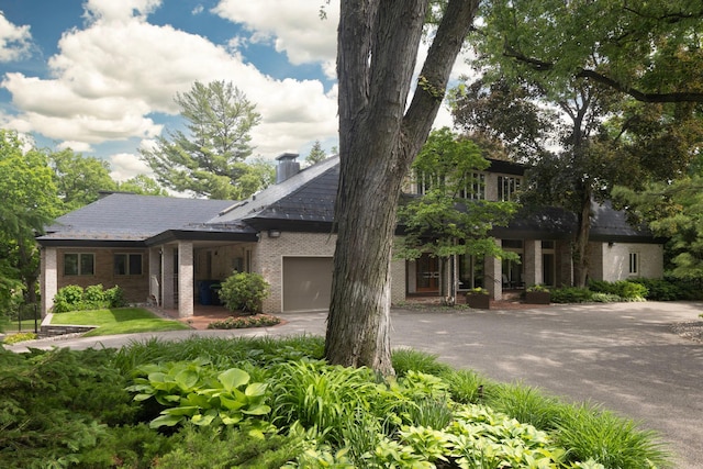 5123 Lake Ridge Rd, Edina, MN 55436 - view of front of home with brick siding, an attached garage, asphalt driveway, and a chimney