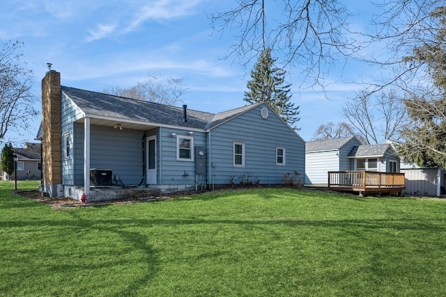 rear view of property with a yard, central AC, a deck, and a chimney