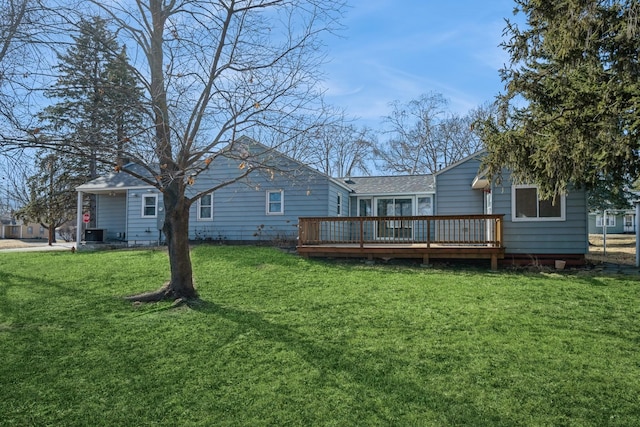 back of property with a deck and a lawn