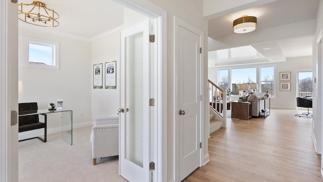 corridor featuring a wealth of natural light, stairway, baseboards, and ornamental molding