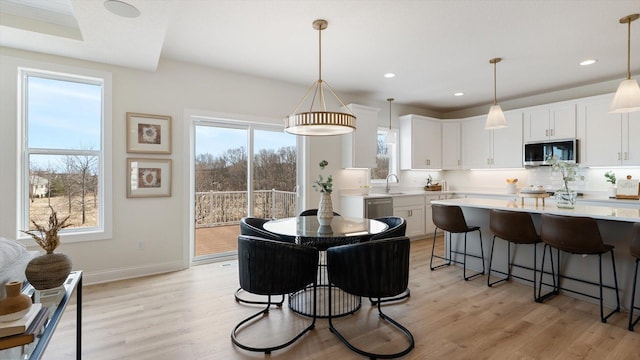 dining room featuring recessed lighting, light wood-type flooring, and baseboards