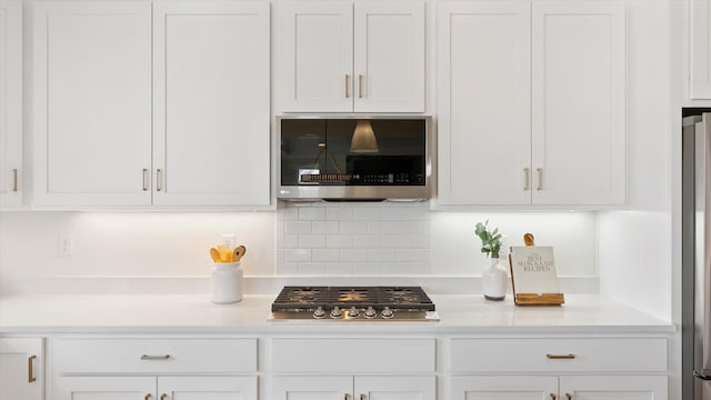 kitchen featuring appliances with stainless steel finishes, white cabinets, and light countertops