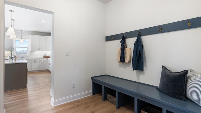 mudroom with a sink, baseboards, recessed lighting, and light wood finished floors