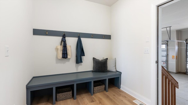 mudroom featuring visible vents, light wood-style flooring, and baseboards