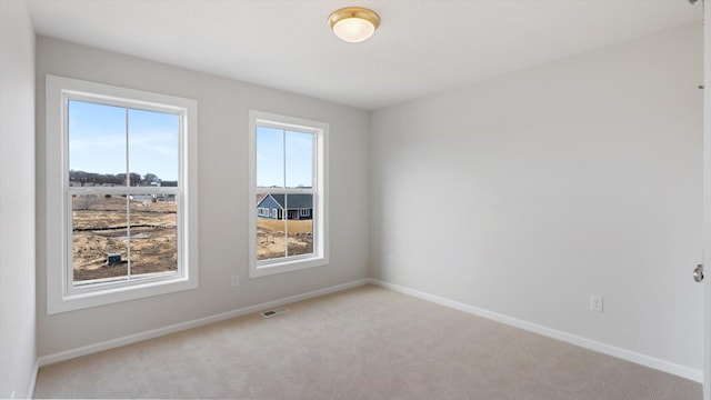 unfurnished room featuring visible vents, baseboards, and carpet