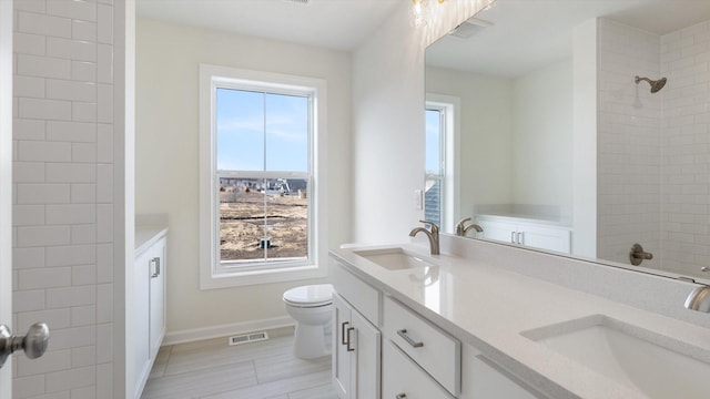 bathroom with a sink, visible vents, and double vanity