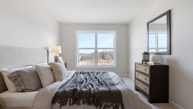 bedroom featuring light carpet and baseboards