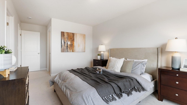 bedroom with light colored carpet and baseboards