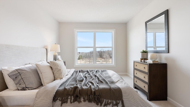 bedroom with light carpet and baseboards