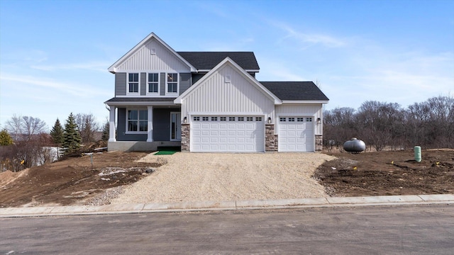 view of front of home featuring stone siding, a garage, driveway, and a shingled roof