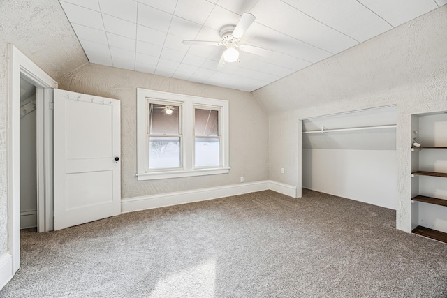 unfurnished bedroom with vaulted ceiling, carpet flooring, a closet, and ceiling fan