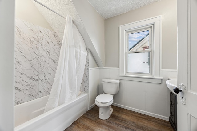 full bathroom featuring a wainscoted wall, shower / tub combo with curtain, wood finished floors, a textured ceiling, and vanity