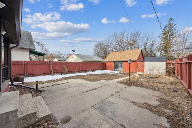 view of patio with an outdoor structure, a storage unit, and a fenced backyard