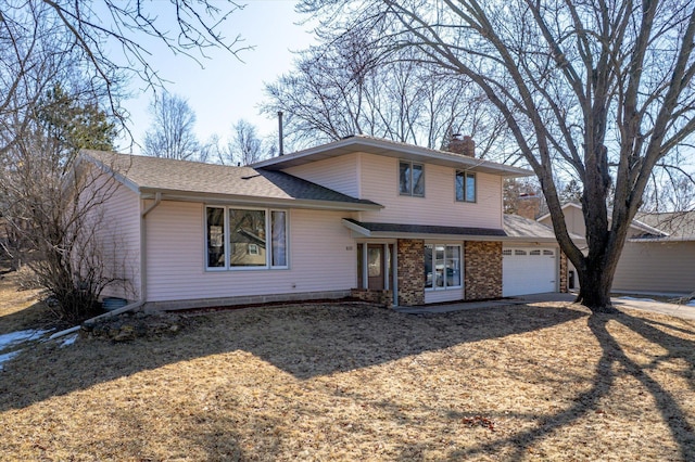 split level home with a garage, brick siding, roof with shingles, and a chimney