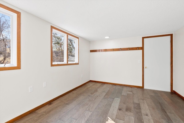 spare room featuring wood finished floors and baseboards