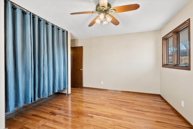 unfurnished room featuring light wood finished floors, a ceiling fan, and baseboards