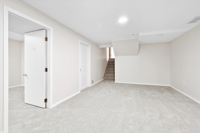 finished below grade area featuring visible vents, baseboards, carpet flooring, and stairs