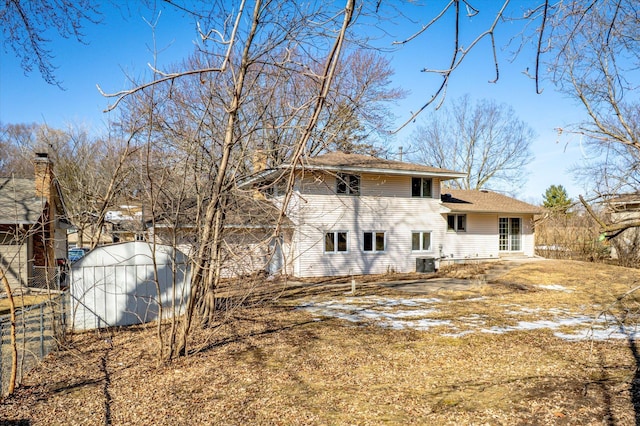 back of house featuring a storage shed, an outbuilding, central air condition unit, and fence