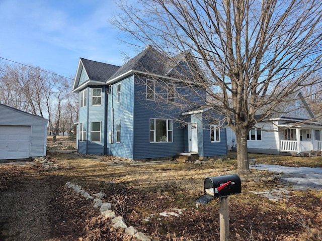 view of front of home featuring a garage, roof with shingles, and an outdoor structure