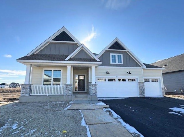 craftsman-style home featuring a porch, a garage, board and batten siding, and driveway